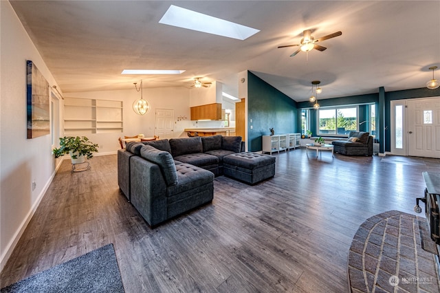 living room featuring lofted ceiling with skylight, dark hardwood / wood-style flooring, and ceiling fan