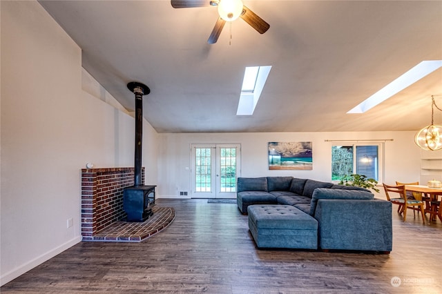 living room featuring a wood stove, dark wood-type flooring, lofted ceiling, and ceiling fan