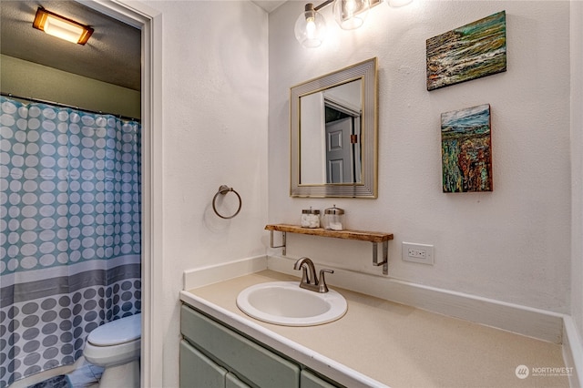 bathroom featuring vanity, curtained shower, and toilet