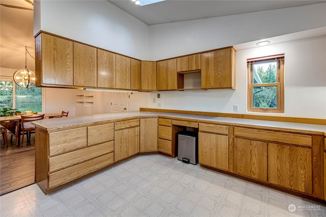 kitchen featuring lofted ceiling, light hardwood / wood-style flooring, a notable chandelier, and decorative light fixtures