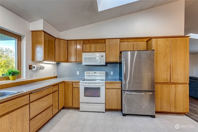 kitchen featuring lofted ceiling, sink, and white appliances