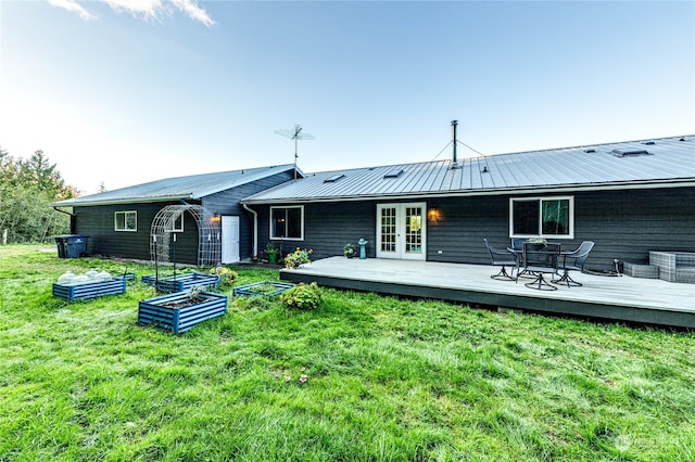 rear view of property featuring french doors, a yard, and a deck