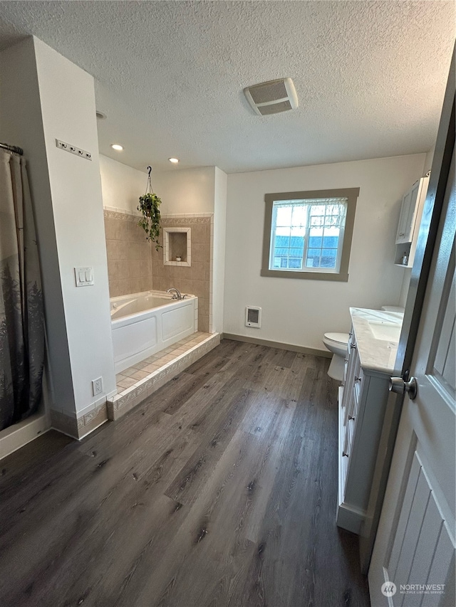 full bathroom with vanity, a textured ceiling, hardwood / wood-style flooring, and toilet