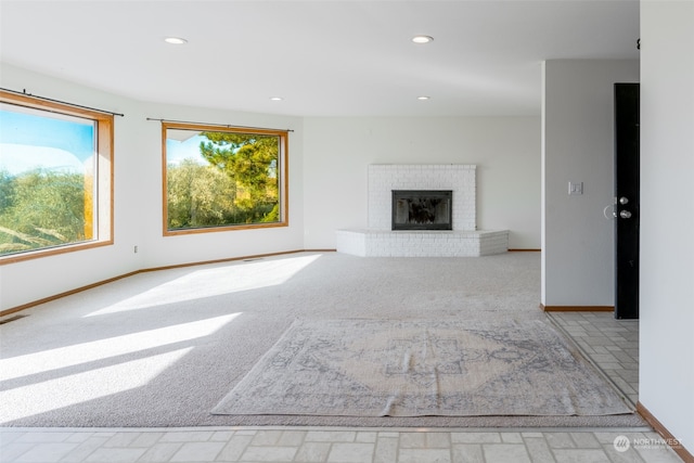 unfurnished living room featuring light carpet and a fireplace