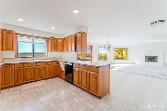 kitchen with pendant lighting, sink, an inviting chandelier, dishwasher, and kitchen peninsula