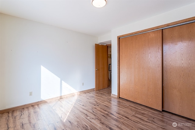 unfurnished bedroom featuring hardwood / wood-style flooring and a closet