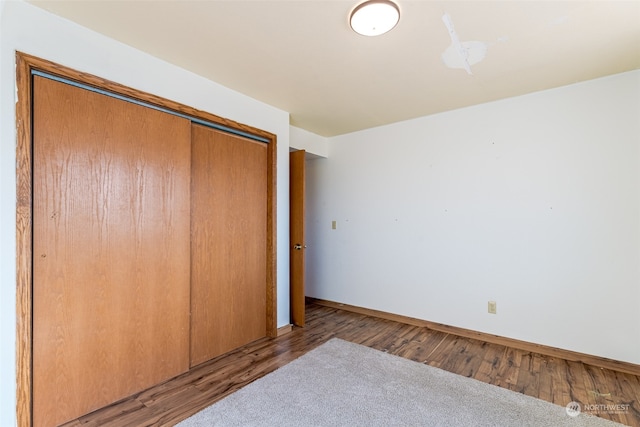 unfurnished bedroom with a closet and light wood-type flooring