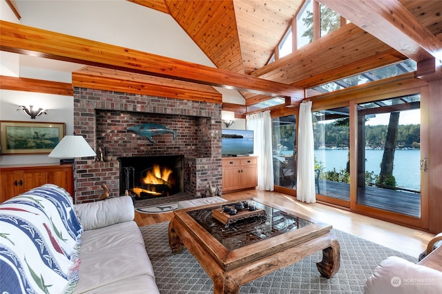 living room featuring light hardwood / wood-style floors, wooden ceiling, a brick fireplace, and vaulted ceiling with beams