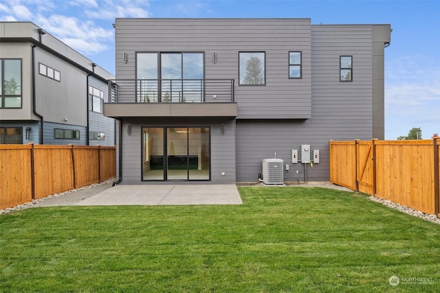 back of house featuring a balcony, a patio area, central AC unit, and a lawn