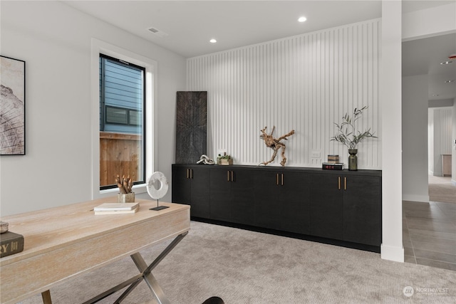 office space featuring wood walls and light colored carpet