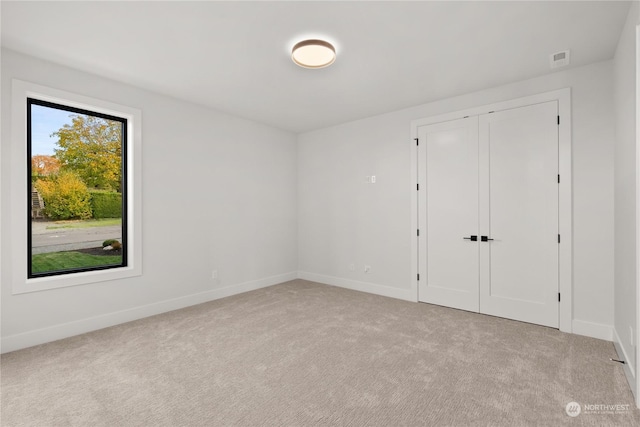 unfurnished room featuring light colored carpet