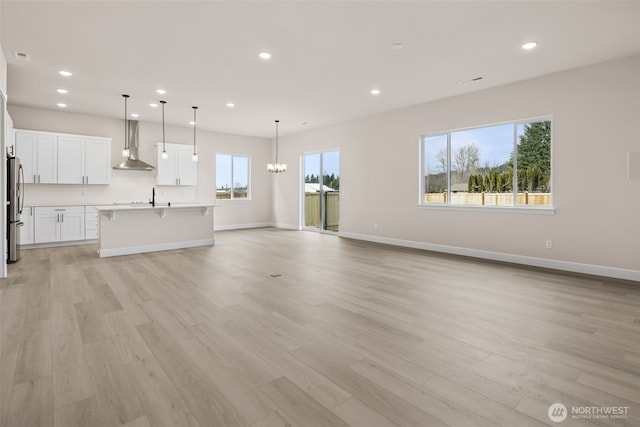 unfurnished living room with baseboards, light wood-style flooring, and recessed lighting