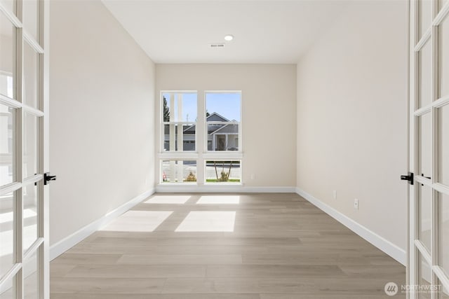 spare room featuring baseboards, visible vents, and french doors