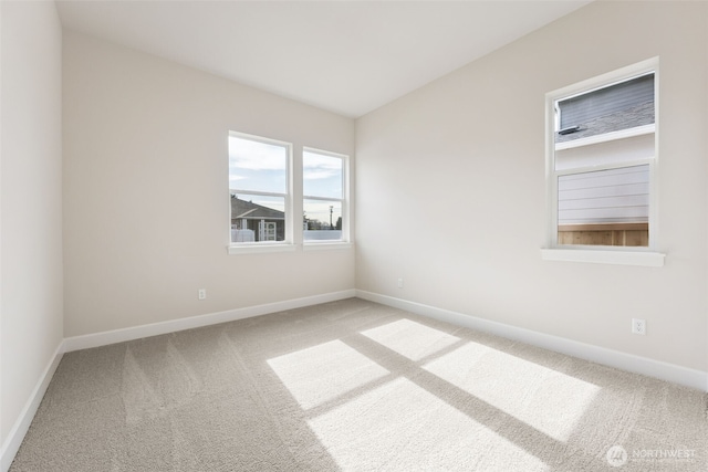 carpeted spare room featuring baseboards