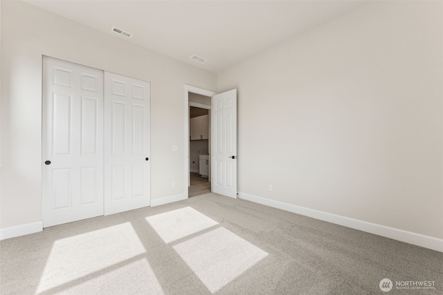 unfurnished bedroom featuring carpet, a closet, visible vents, and baseboards