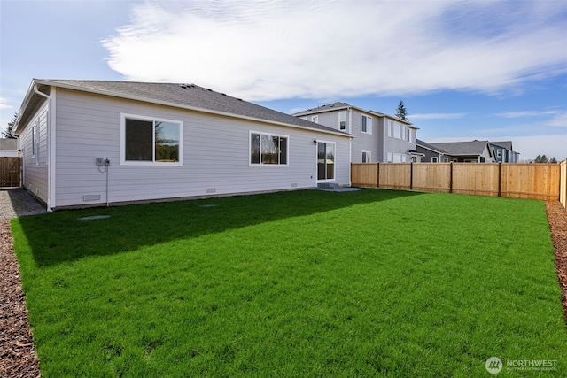 back of house featuring a fenced backyard and a lawn