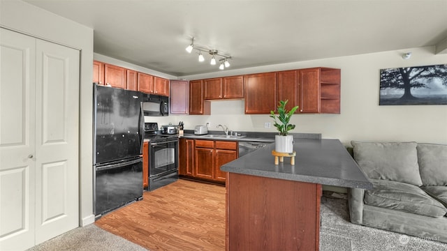 kitchen with black appliances, kitchen peninsula, sink, and light hardwood / wood-style flooring