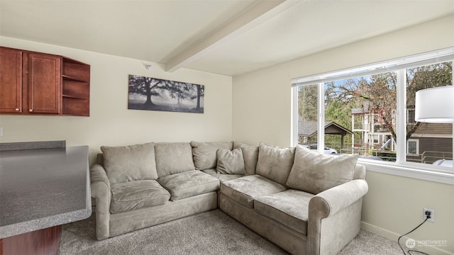 carpeted living room with beamed ceiling