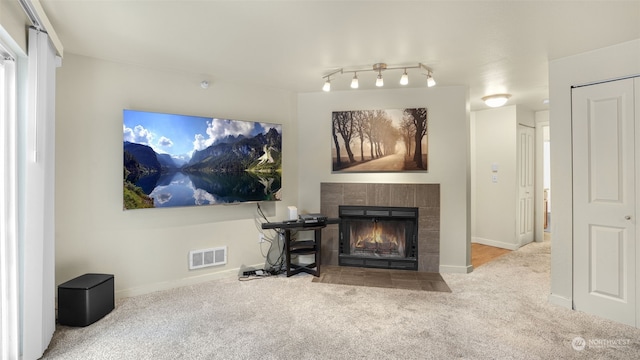 carpeted living room featuring a tile fireplace