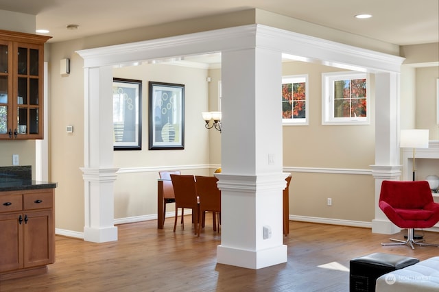 living area featuring crown molding, light hardwood / wood-style flooring, and an inviting chandelier