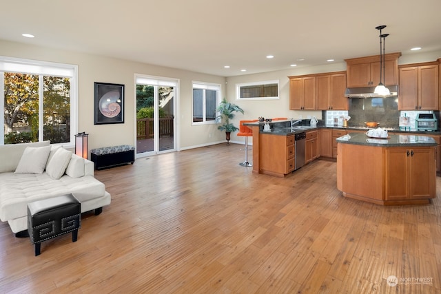 kitchen with decorative light fixtures, light wood-type flooring, a kitchen island, and dishwasher