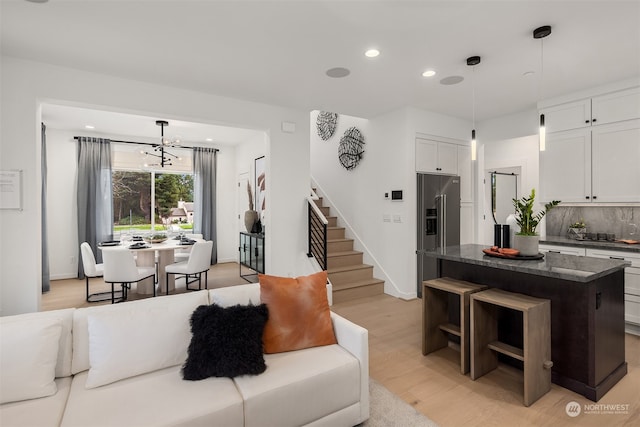 living room featuring light hardwood / wood-style flooring and an inviting chandelier