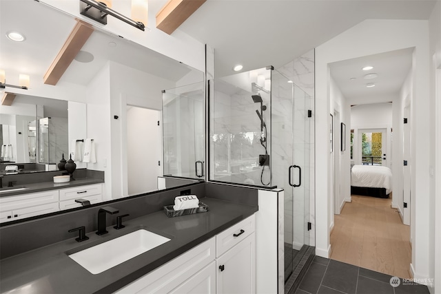 bathroom with hardwood / wood-style floors, vanity, vaulted ceiling, and an enclosed shower