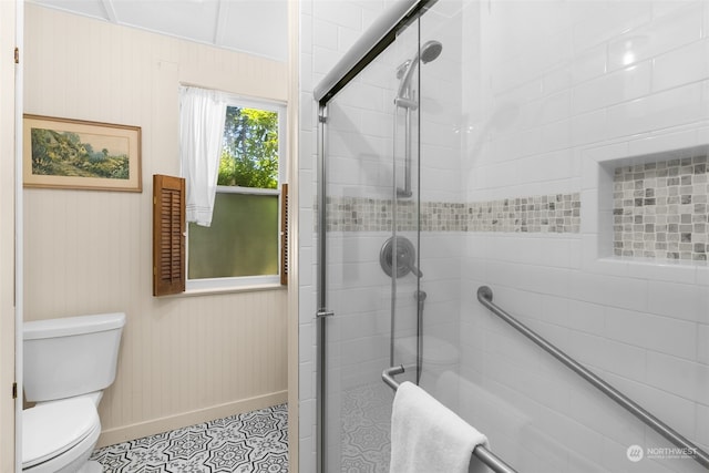 bathroom featuring toilet, wood walls, and walk in shower