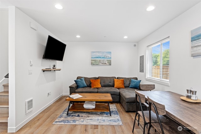 living room with electric panel and light hardwood / wood-style flooring