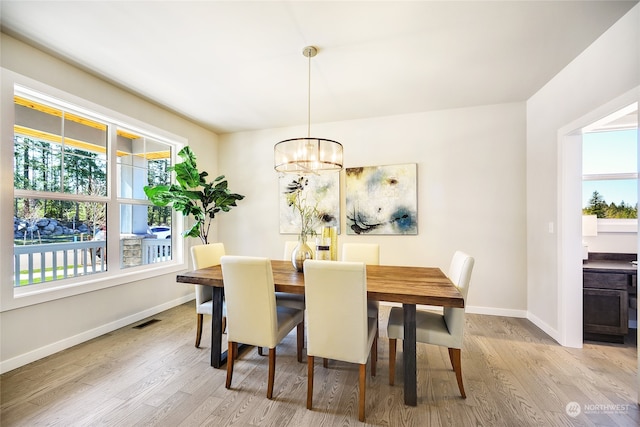 dining space featuring a chandelier and light wood-type flooring