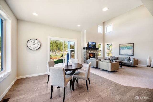 dining room with light hardwood / wood-style flooring and a fireplace