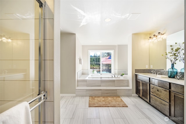 bathroom with vanity and shower with separate bathtub