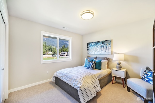 bedroom with light carpet and a closet