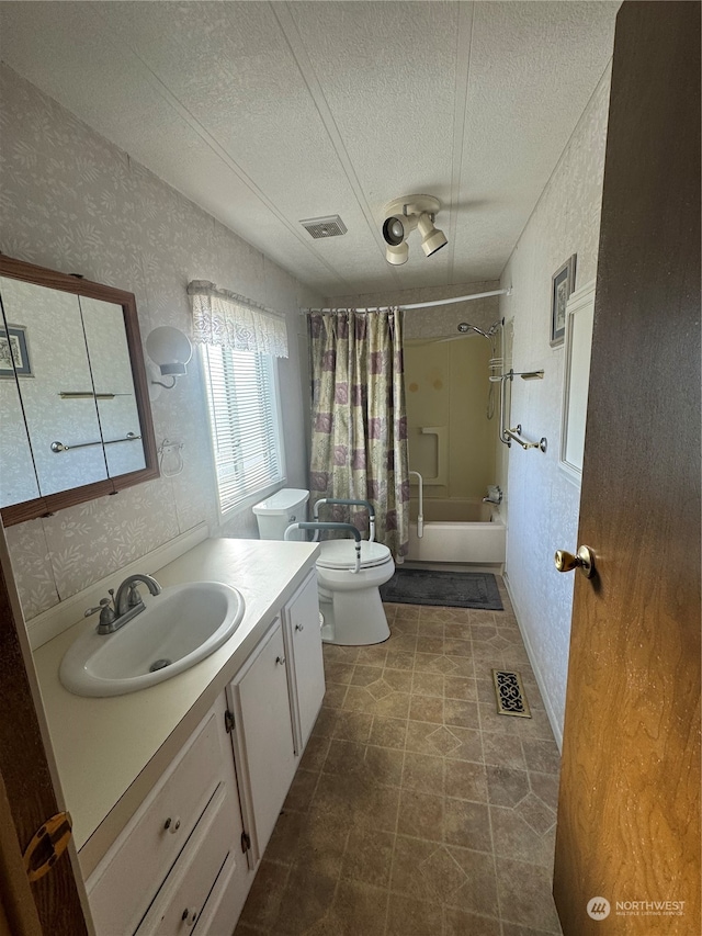 full bathroom featuring vanity, shower / bath combination with curtain, a textured ceiling, and toilet