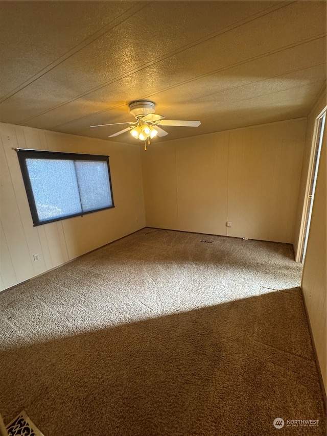 empty room featuring carpet flooring and ceiling fan