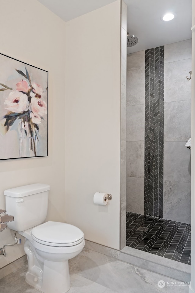 bathroom with toilet and tiled shower