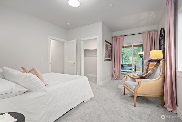 bedroom featuring light carpet, a walk in closet, and a closet