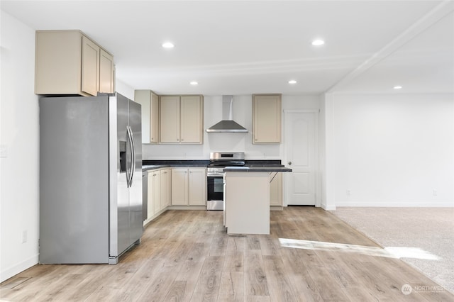 kitchen with wall chimney range hood, cream cabinets, light wood-type flooring, a kitchen island, and stainless steel appliances