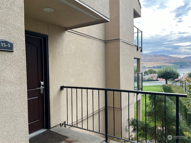 view of exterior entry featuring a mountain view and a balcony