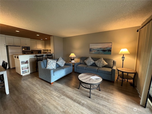 living room with dark wood-type flooring and a textured ceiling