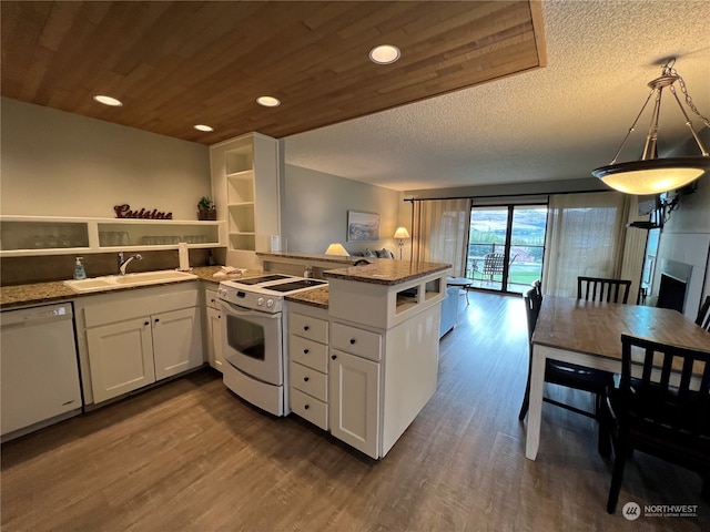 kitchen with kitchen peninsula, sink, pendant lighting, white cabinets, and white appliances