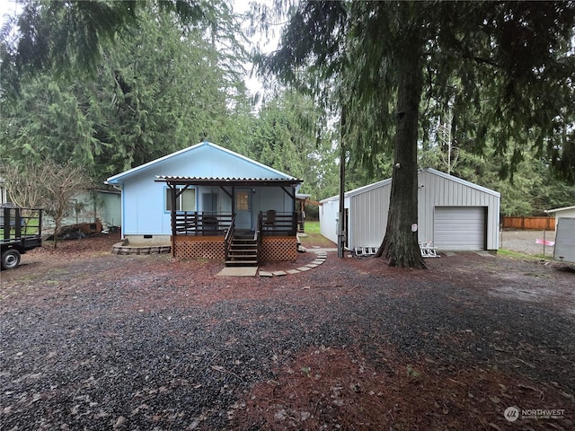 view of front facade with a garage, an outdoor structure, and a wooden deck