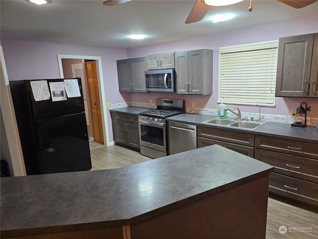 kitchen with gray cabinets, stainless steel appliances, light hardwood / wood-style flooring, and sink