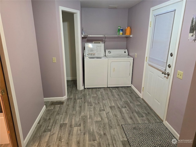 laundry room featuring independent washer and dryer and light hardwood / wood-style floors