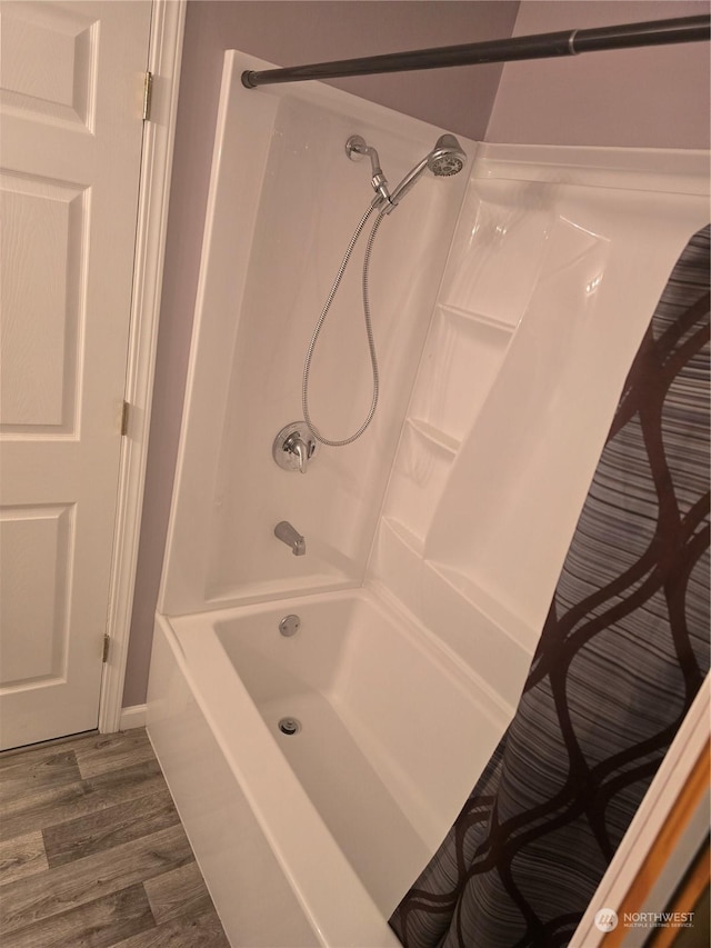 bathroom featuring hardwood / wood-style flooring and shower / tub combo with curtain