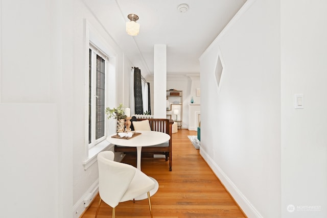 hall with wood-type flooring and ornamental molding