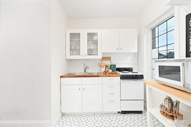 kitchen featuring white cabinetry, butcher block counters, sink, and white appliances