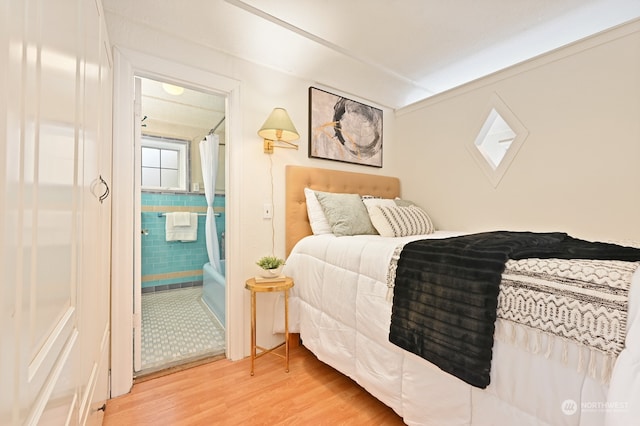 bedroom featuring hardwood / wood-style flooring and tile walls