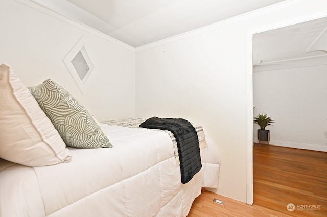 bedroom featuring hardwood / wood-style floors and crown molding