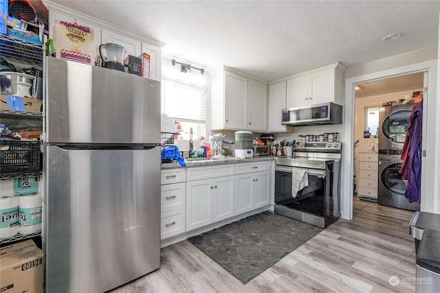 kitchen with white cabinets, stainless steel appliances, and light hardwood / wood-style floors